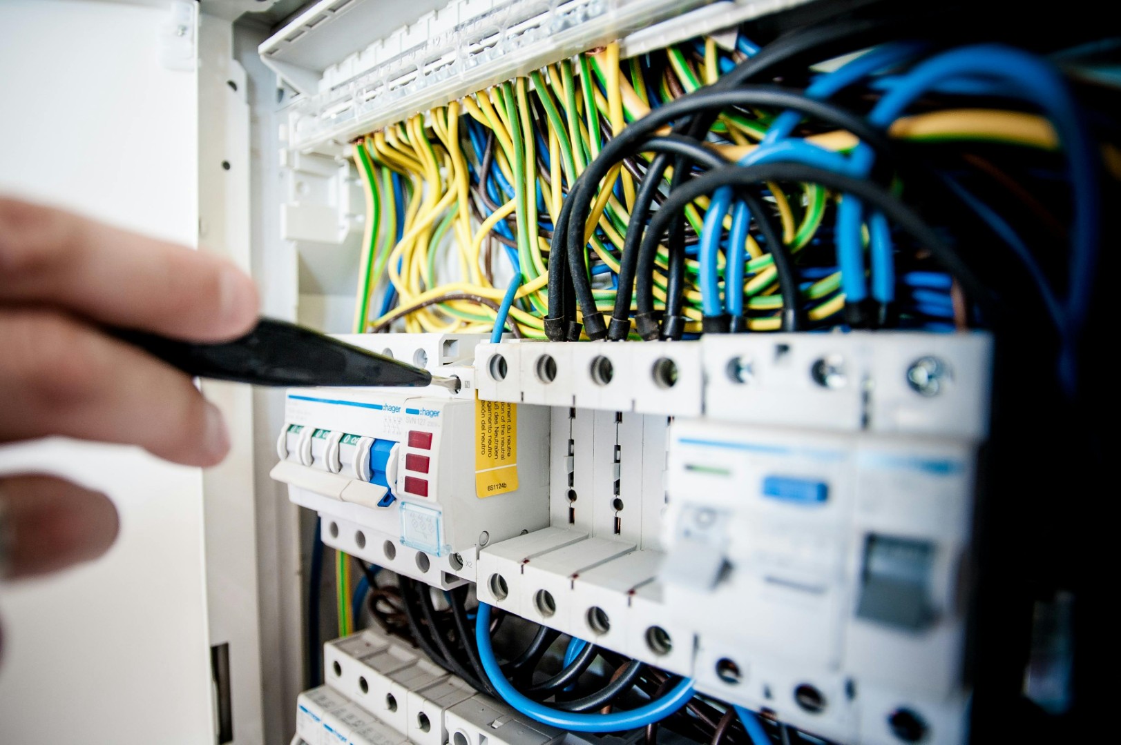 Professional electrician working on electrical panel showing comprehensive electrical services